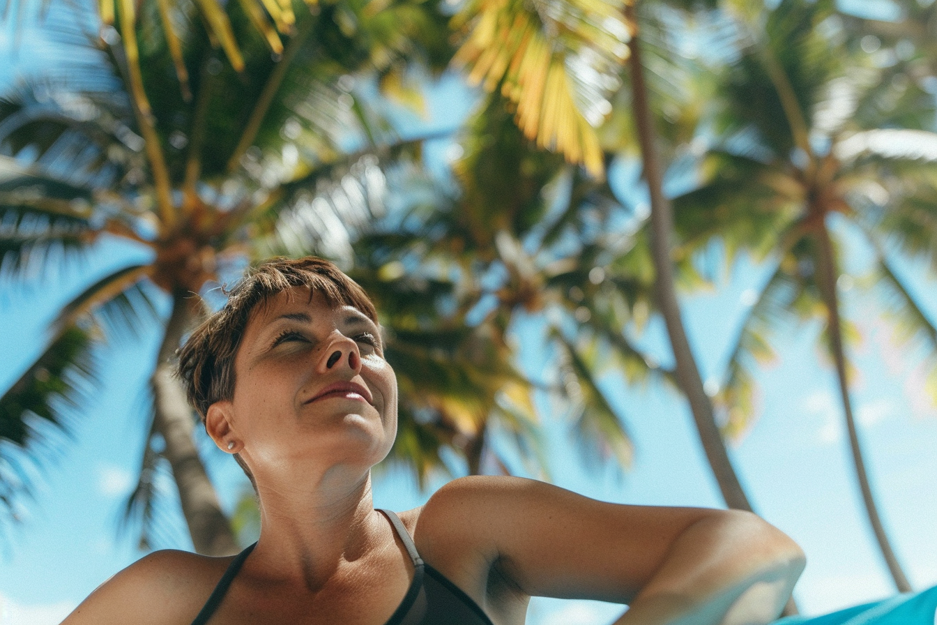 Image gratuite Femme d&rsquo;âge moyen bronzant sur un tapis de plage près des palmiers 3
