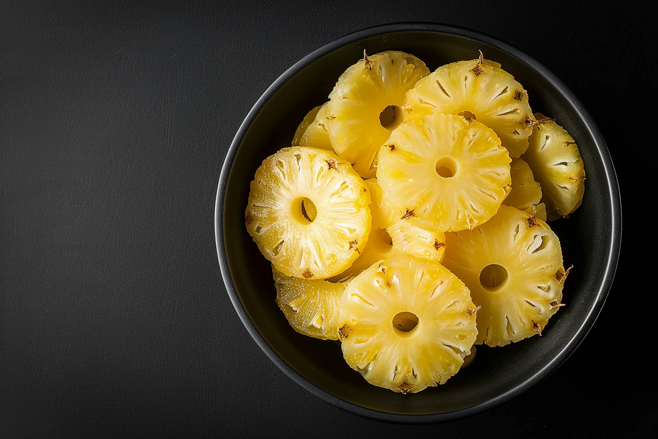 Image gratuite Tranches d&rsquo;ananas dans un bol sur fond noir 2