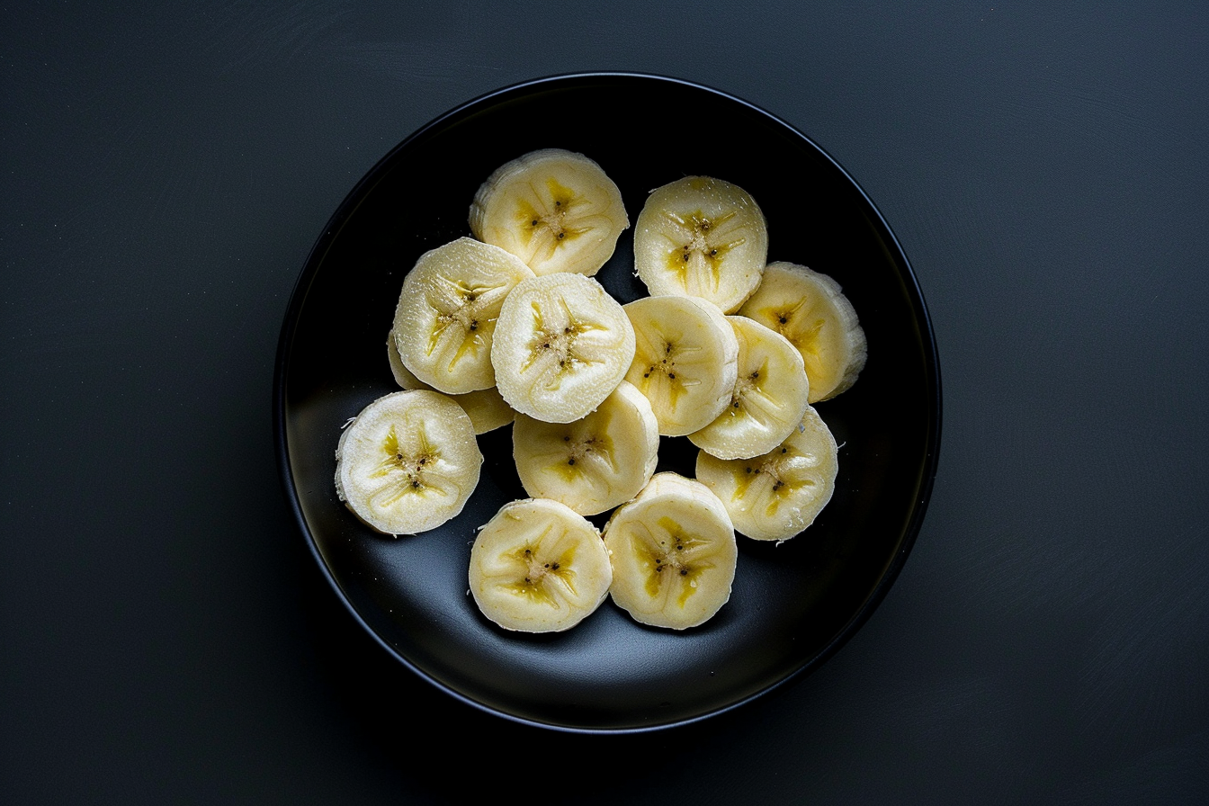 Image gratuite Tranches de banane dans un bol sur fond noir 7