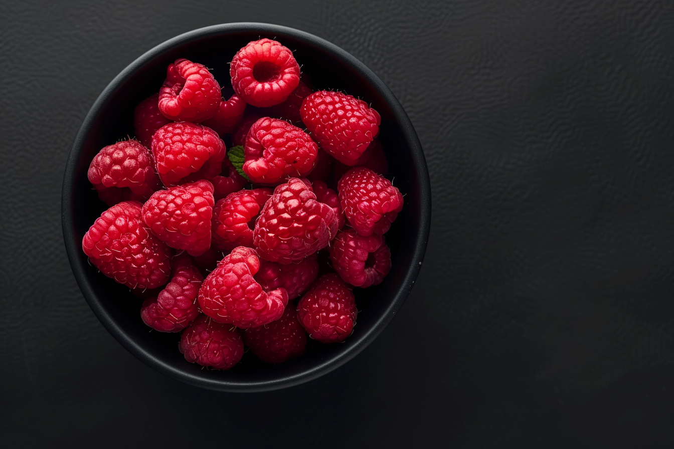 Image gratuite Tranches de framboise dans bol sur fond noir 2